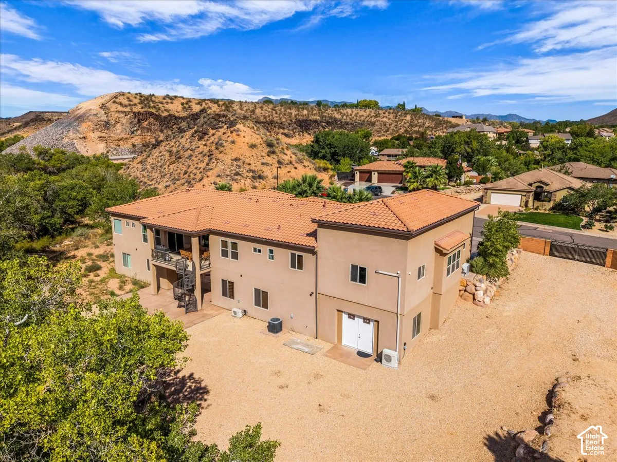Terracotta-tiled roof, multi-level exterior, spiral staircase, and a desert-inspired landscape