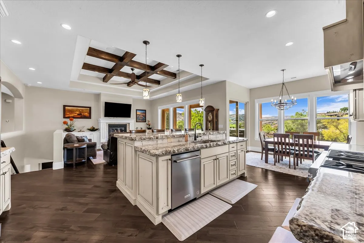Expansive kitchen island with stone countertops and integrated dishwasher, wood-finish flooring, and recessed lighting