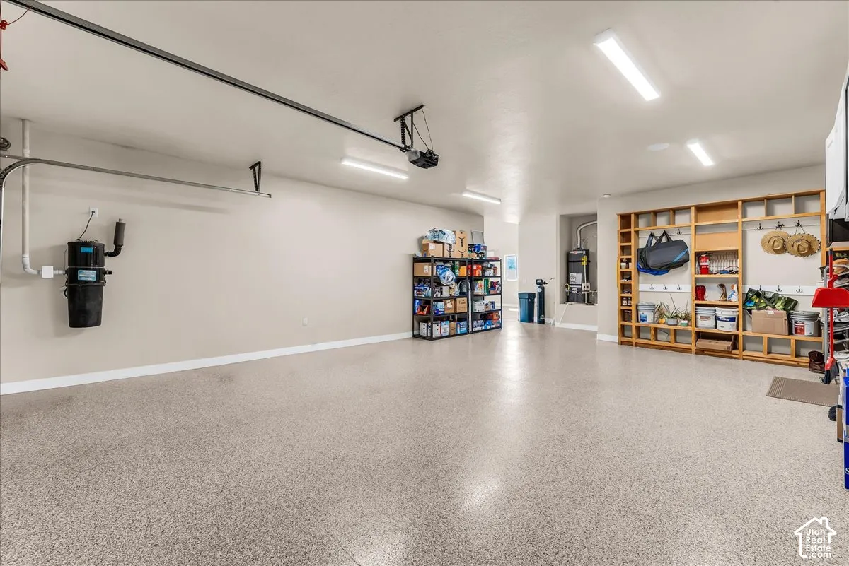Epoxy-coated flooring, built-in shelving, recessed utility area, wall-mounted central vacuum system, and overhead fluorescent lighting