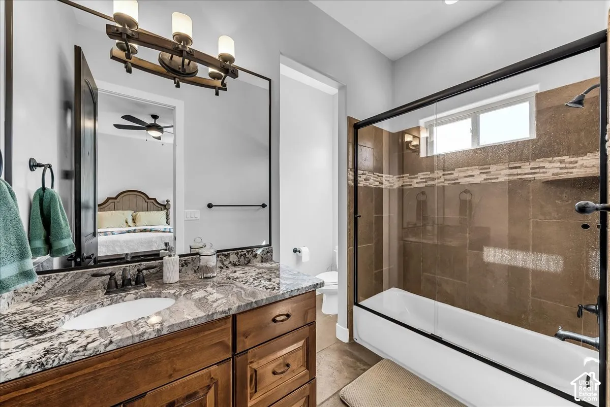 Double vanity with stone countertop, undermount sinks, and dark wood cabinetry