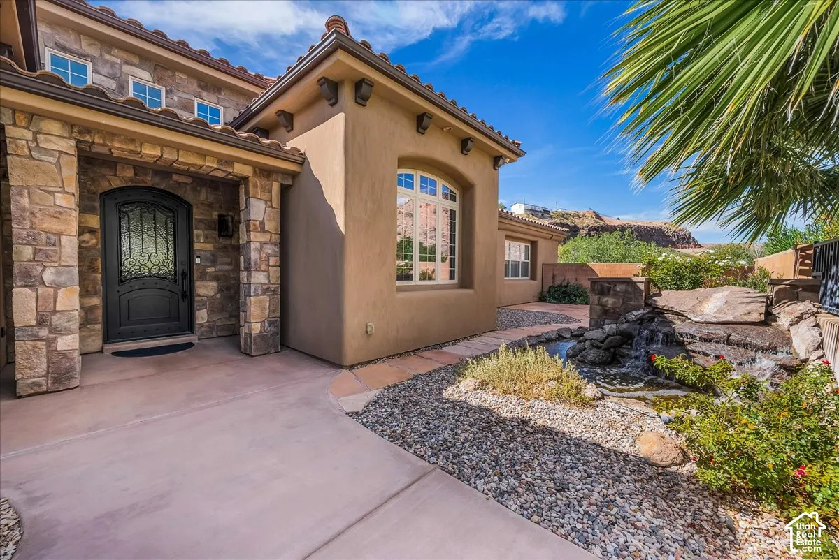 Stucco exterior featuring stone accents and a terracotta tile roof