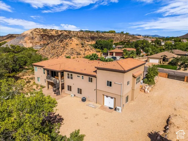 Terracotta-tiled roof, multi-level exterior, spiral staircase, and a desert-inspired landscape