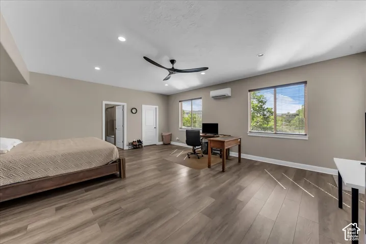 Spacious room featuring wood-finish flooring, recessed lighting, and a contemporary ceiling fan