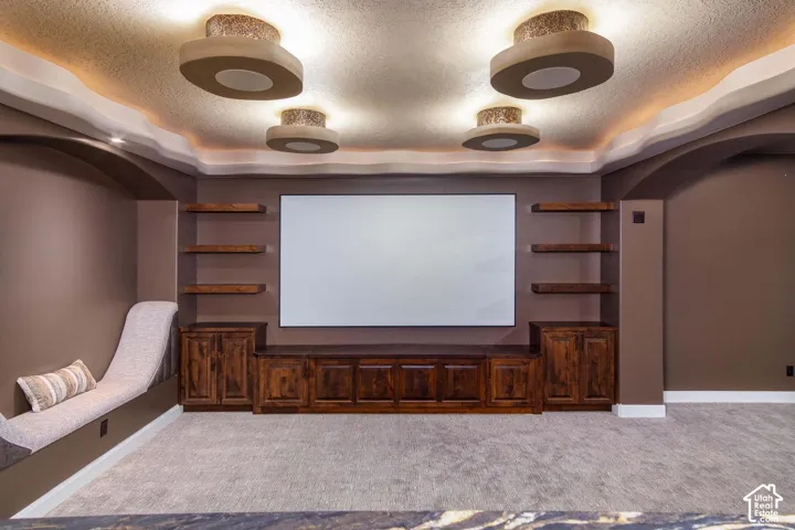 Built-in entertainment center with wood-finish cabinetry, floating shelves, and a large projection screen