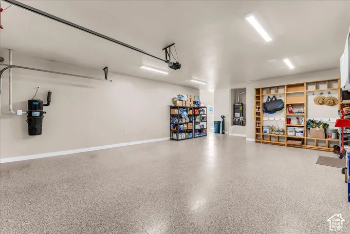 Epoxy-coated flooring, built-in shelving, recessed utility area, wall-mounted central vacuum system, and overhead fluorescent lighting