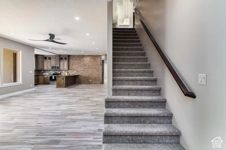 Open-concept living space with wood-finish flooring, recessed lighting, and a modern ceiling fan