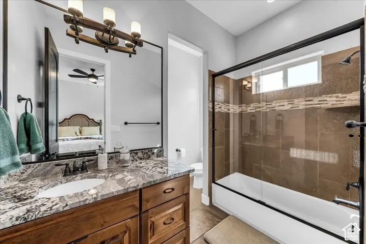 Double vanity with stone countertop, undermount sinks, and dark wood cabinetry