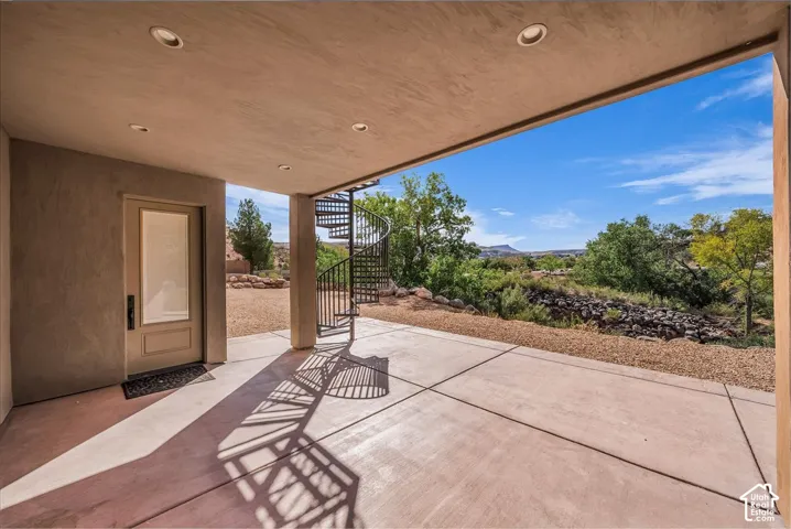Covered patio featuring recessed lighting, a spiral staircase, and a concrete surface