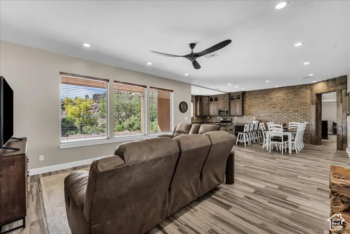 Open-concept living space featuring wood-finish flooring, recessed lighting, and a modern ceiling fan