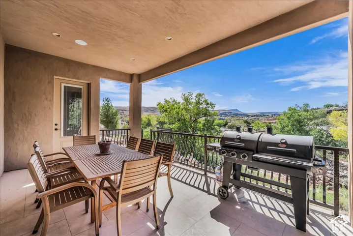 Covered outdoor patio with a durable tiled floor and a sturdy metal railing