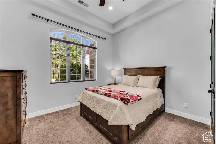 Tray ceiling, arched window, recessed lighting, carpet flooring, and dark wood trim