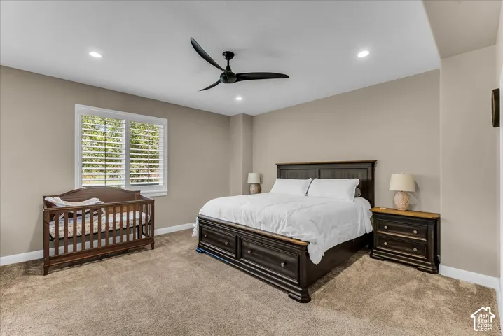 Recessed lighting, ceiling fan, neutral wall paint, window with plantation shutters, and carpeted flooring