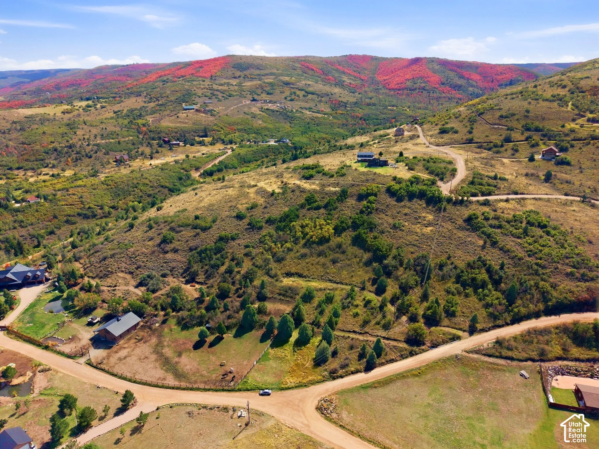 Expansive mountain landscape with diverse foliage and scattered residential structures