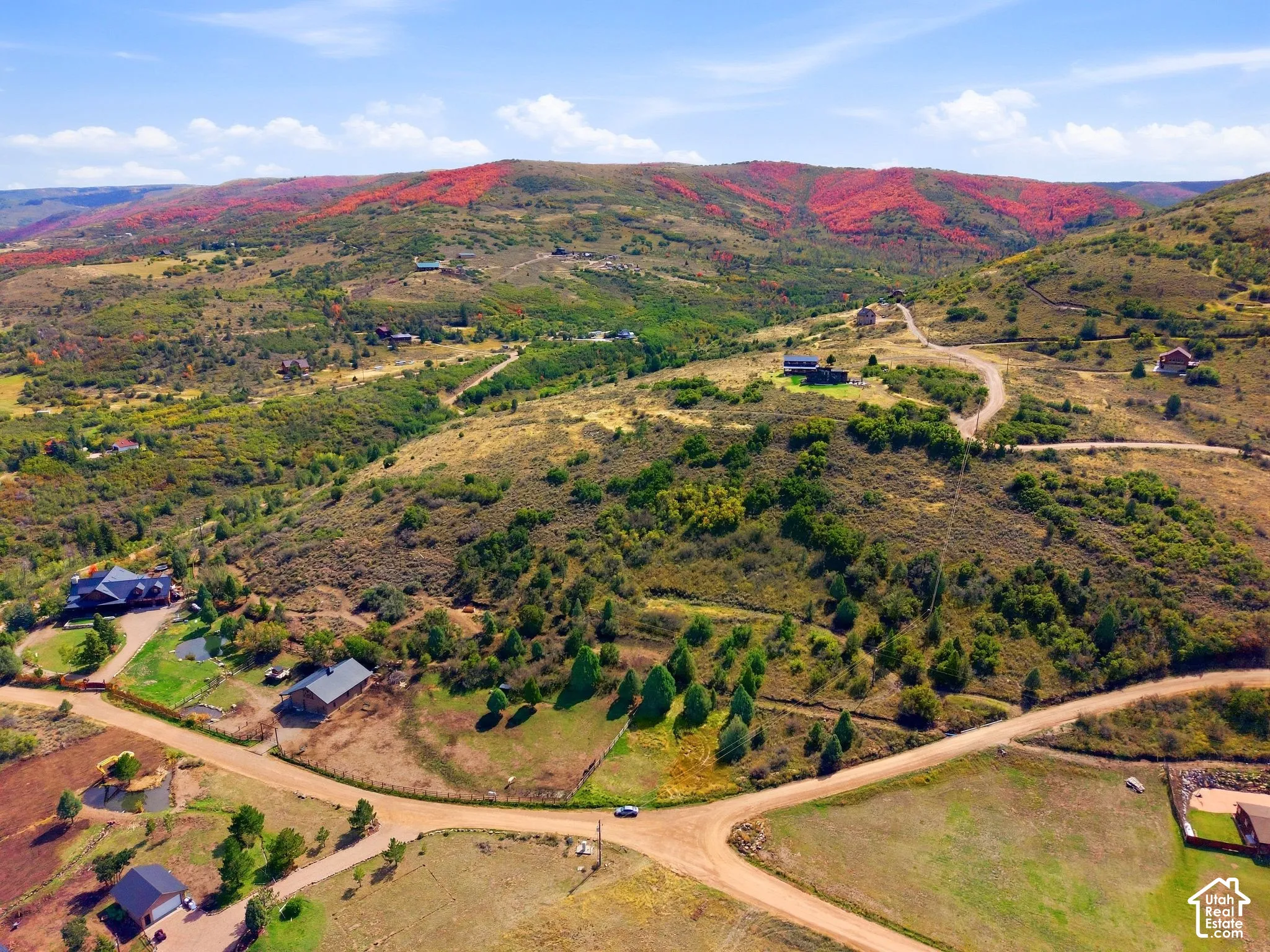 Expansive mountainous terrain with varied vegetation and scattered residential structures
