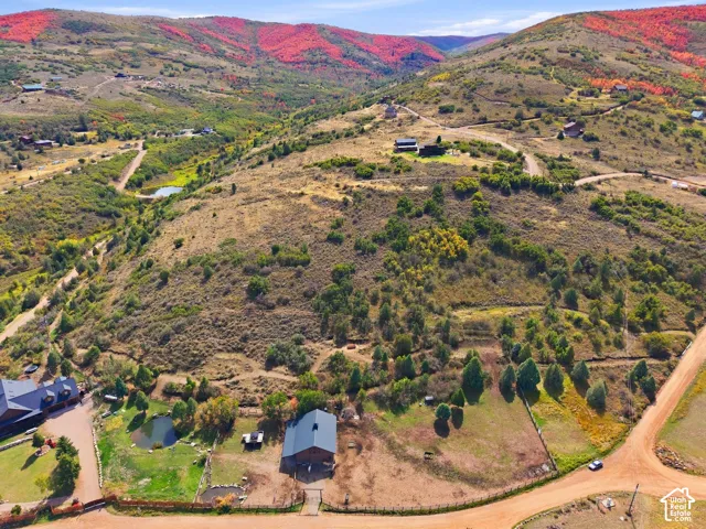 Expansive natural landscape with varied topography, including multiple structures and winding roads