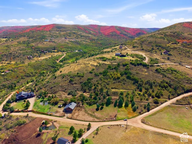 Expansive mountainous terrain with varied vegetation and multiple residences
