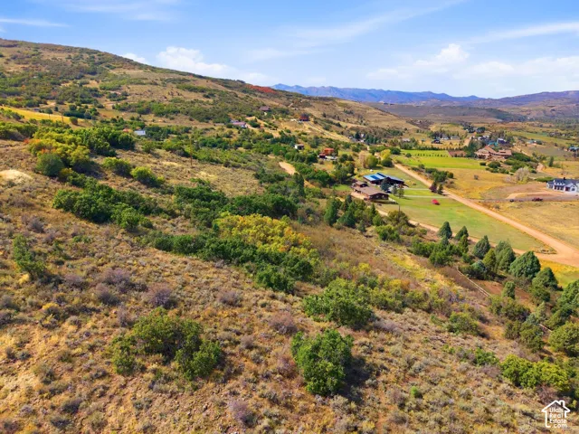 Expansive terrain featuring varied vegetation, distant structures, and open sky