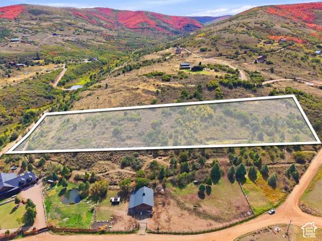 Expansive plot featuring natural vegetation and surrounding mountainous terrain