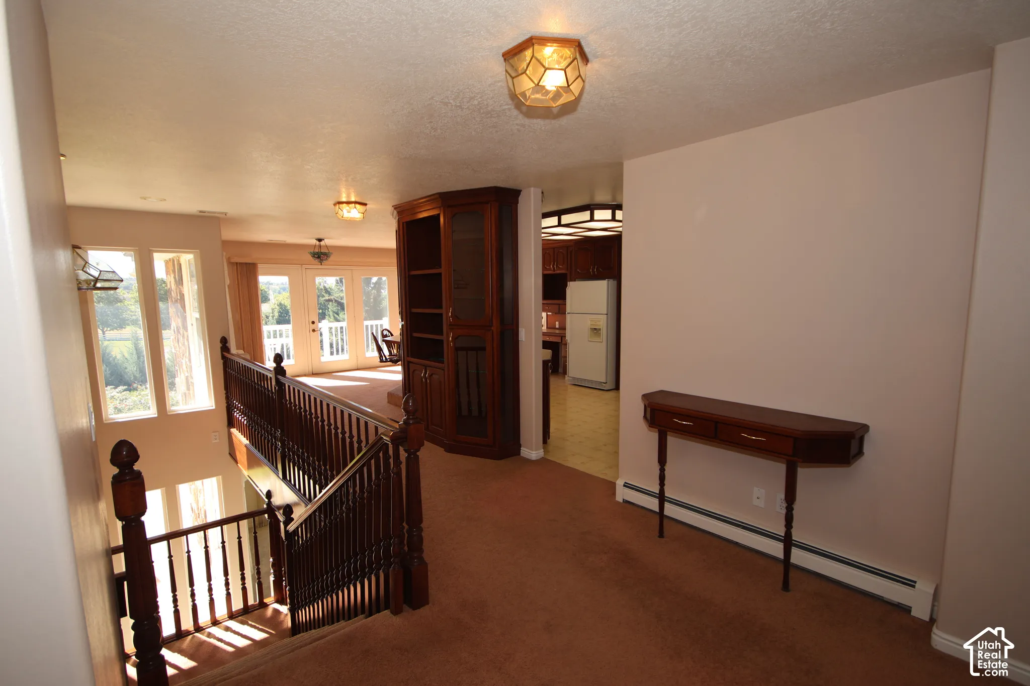 Wooden staircase with turned balusters, built-in shelving unit, and multiple windows