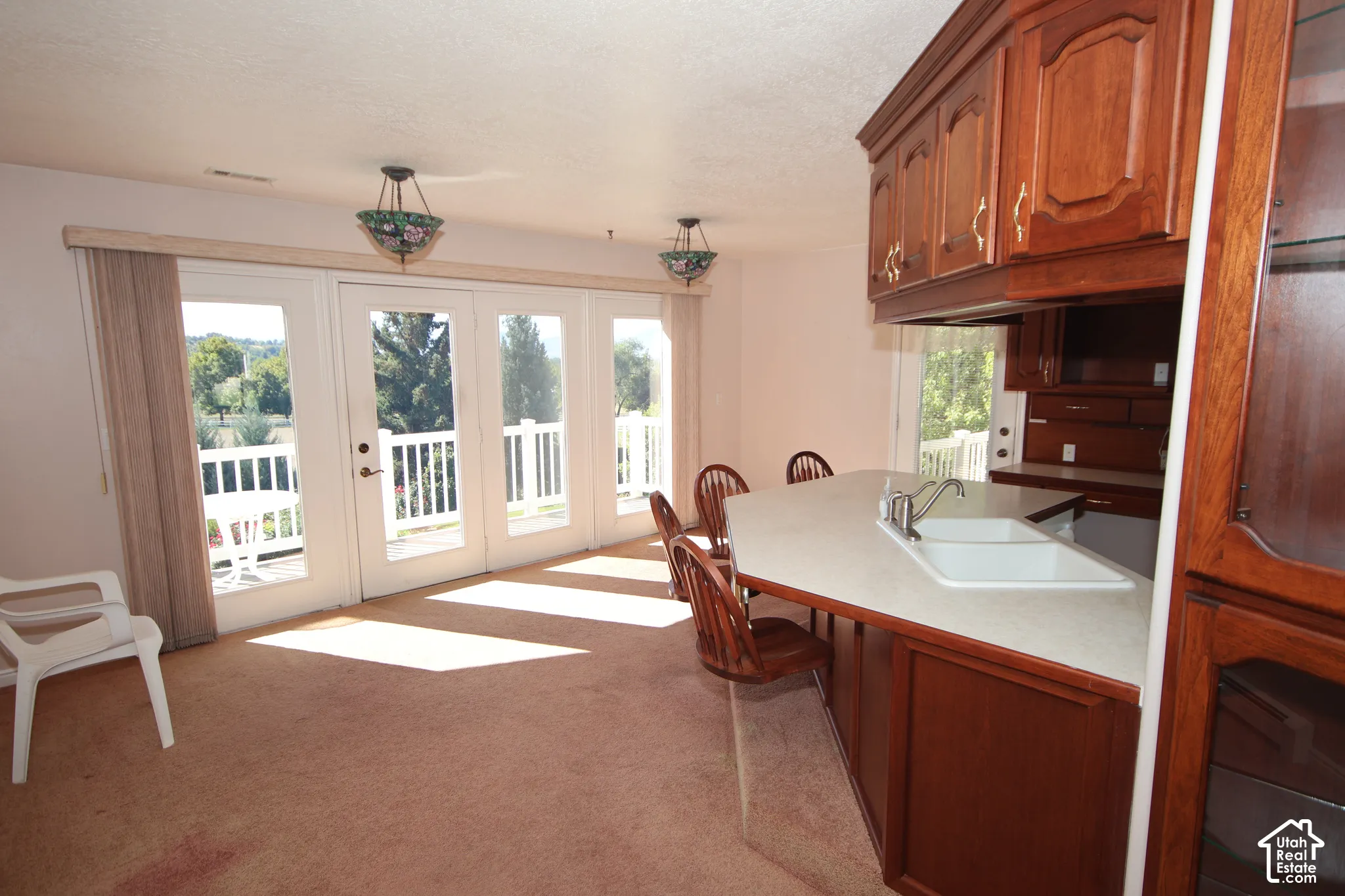 Built-in cabinetry with ornate hardware, integrated double sink, and peninsula counter