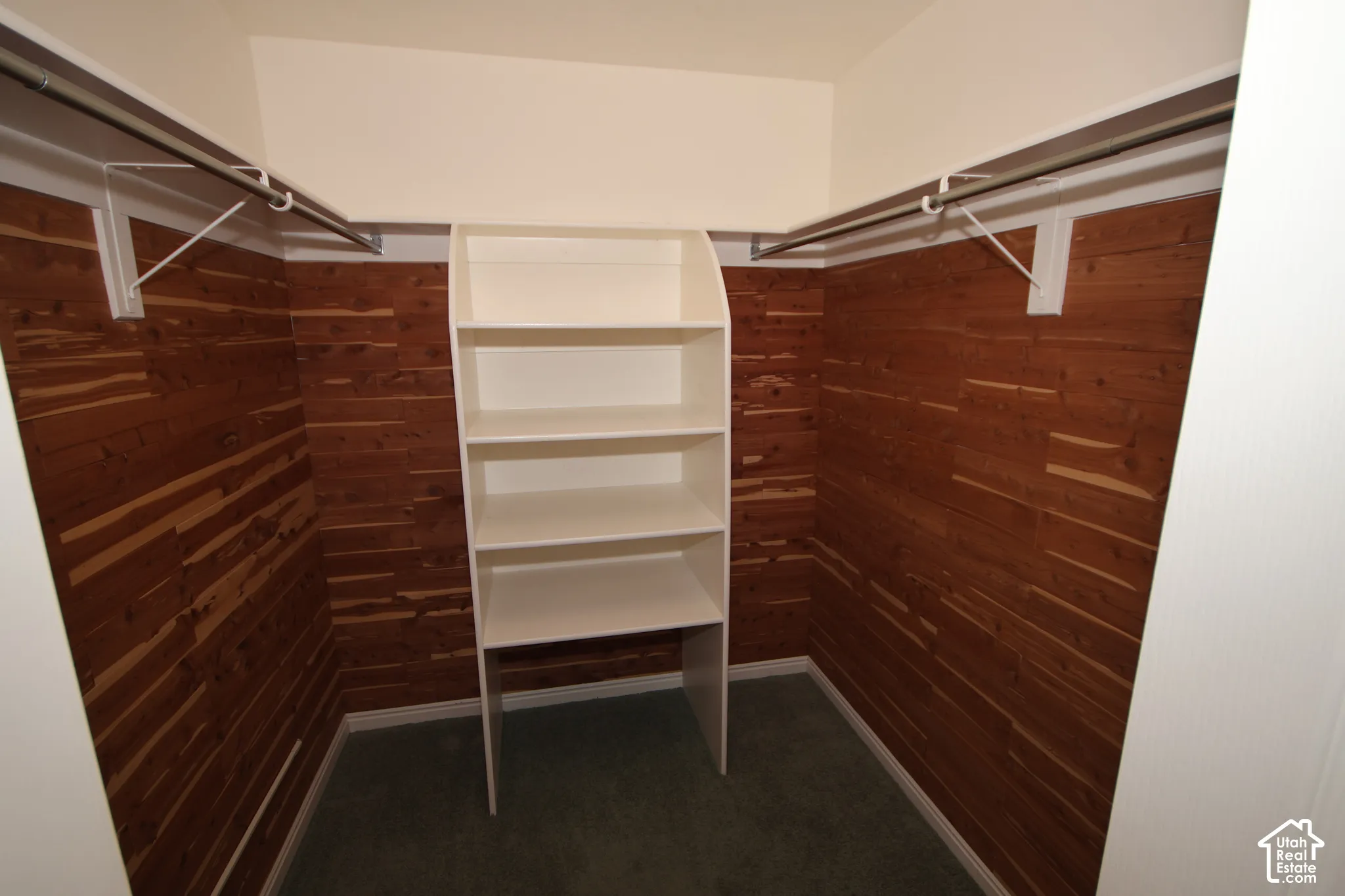 Integrated shelving unit, dual closet rods, cedar-paneled walls, and carpet flooring