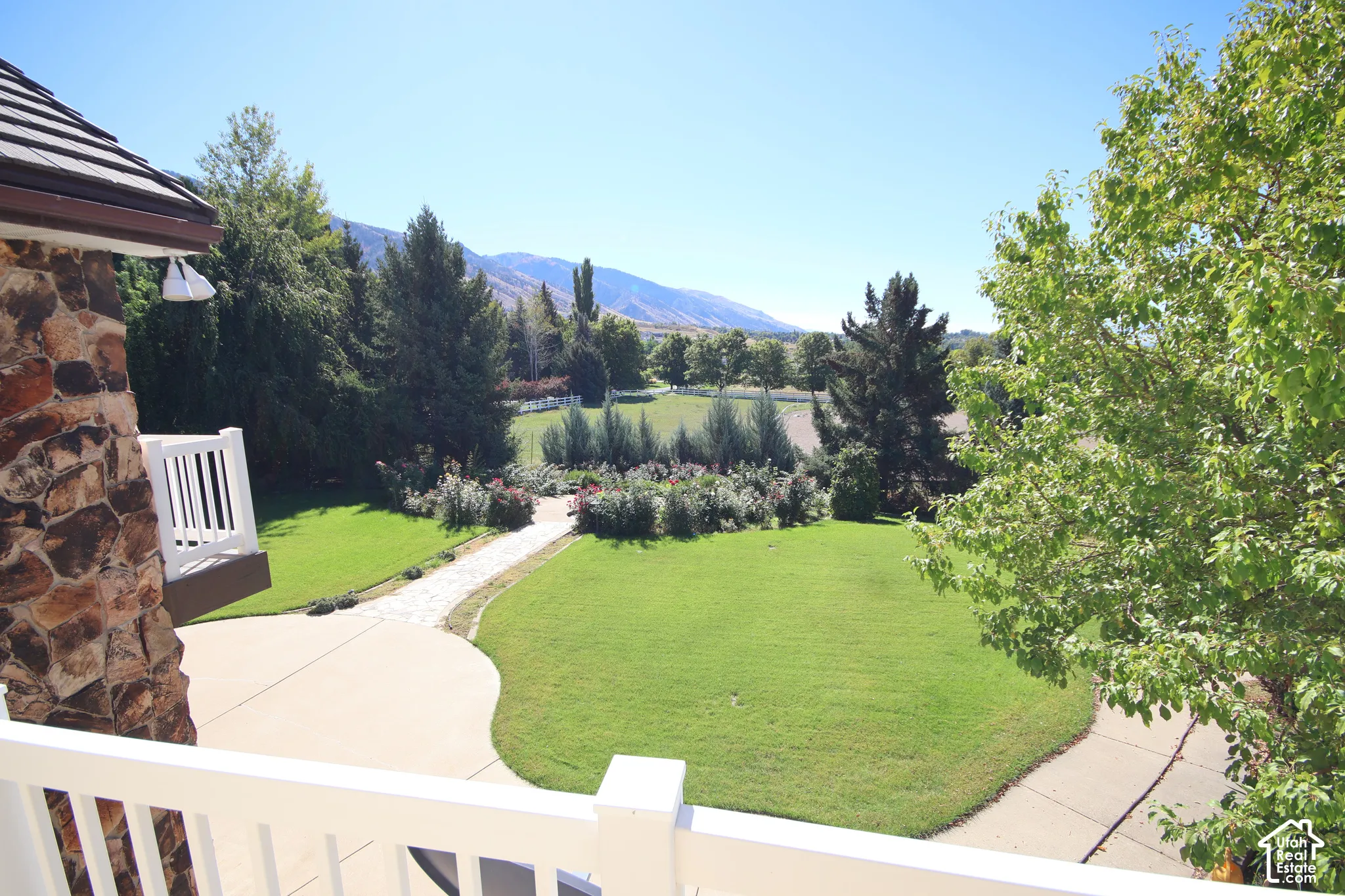 Manicured lawn with a stone pathway, mature trees, and landscaping