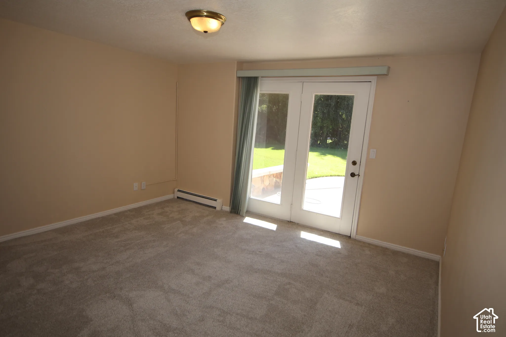 Plush carpeting, French doors, and ceiling-mounted lighting