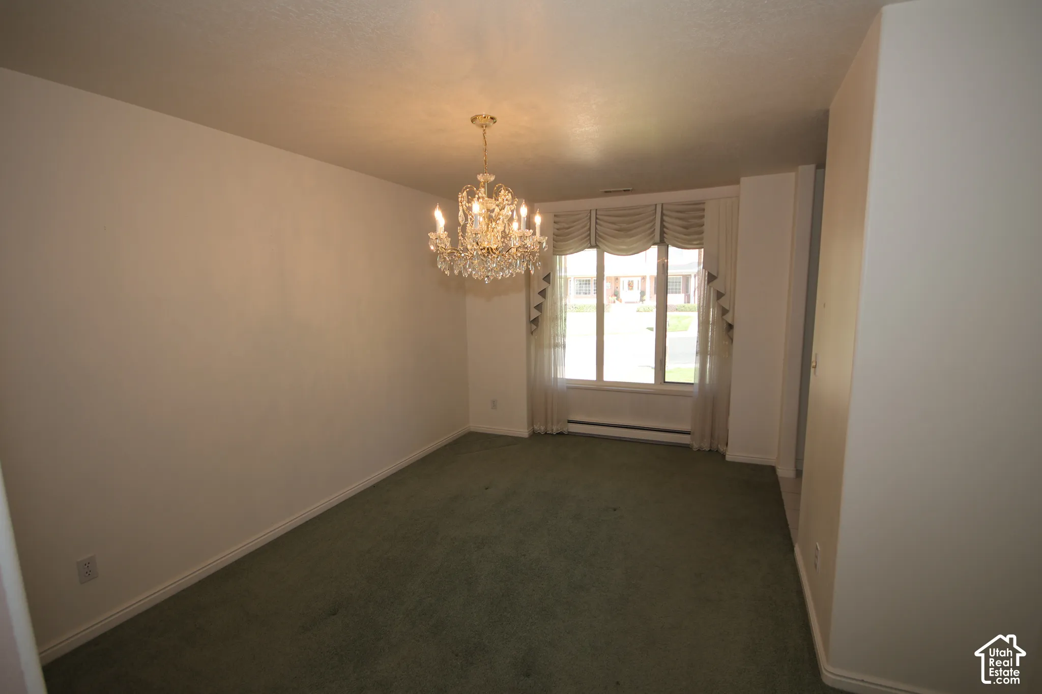 Chandelier lighting, wall-to-wall carpeting, and a bay window