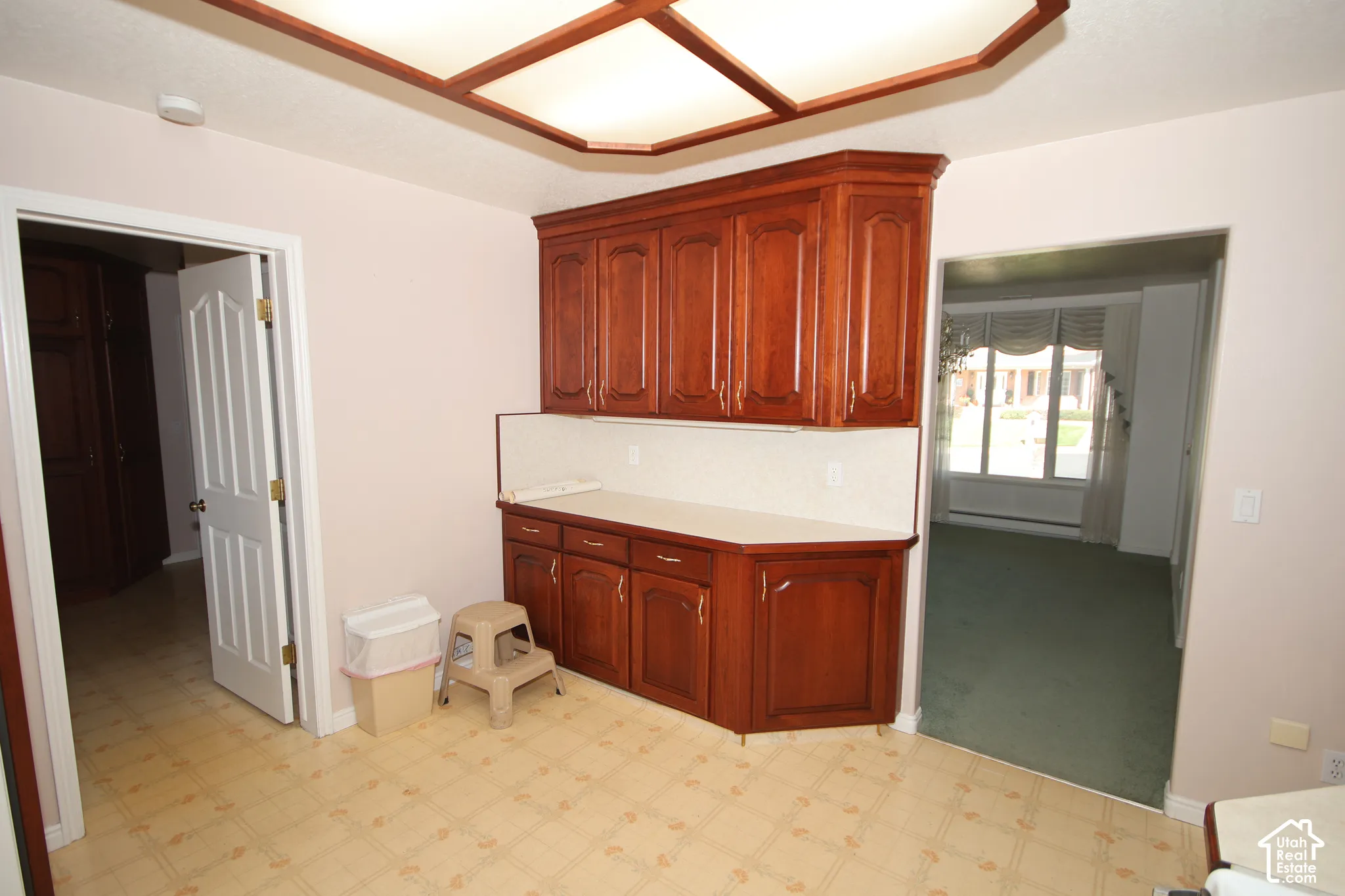 Wood-finish cabinetry with a solid surface countertop and tile backsplash