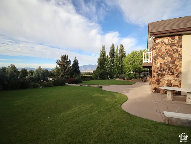 Expansive lawn with established landscaping and mountain scenery