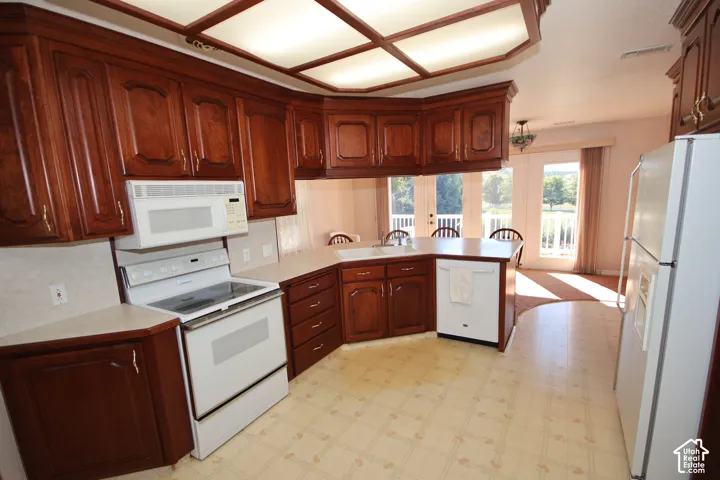 Wood-finish cabinetry, built-in microwave, white electric range, and a white refrigerator