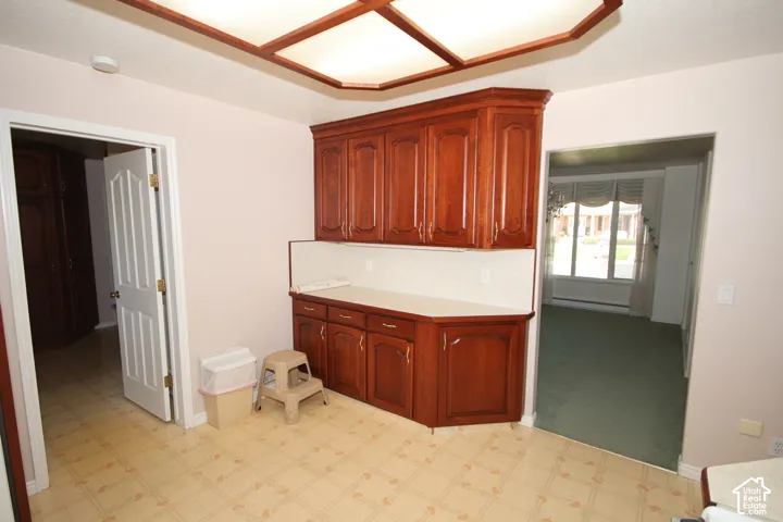 Wood-finish cabinetry with a solid surface countertop and tile backsplash