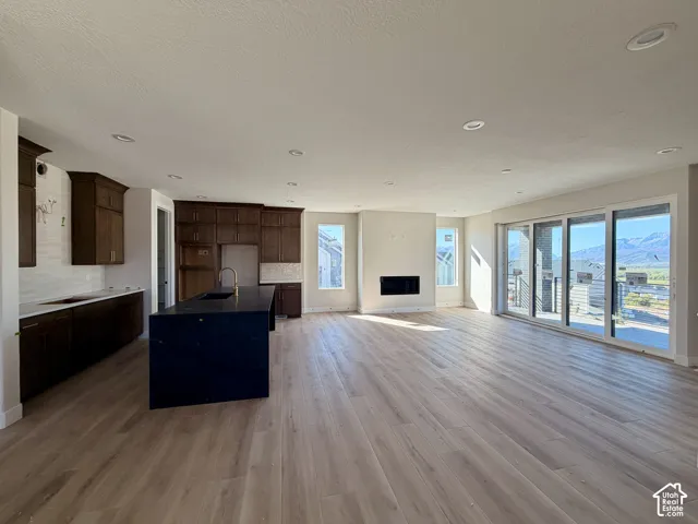 Main floor featuring a chef's kitchen, floor to ceiling fireplace and multi-panel sliding glass door