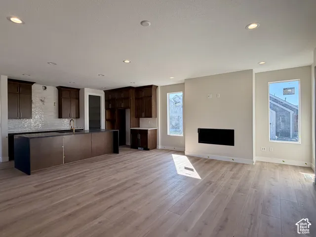 Chef's kitchen featuring waterfall island, stacked cabinets and tile backsplash