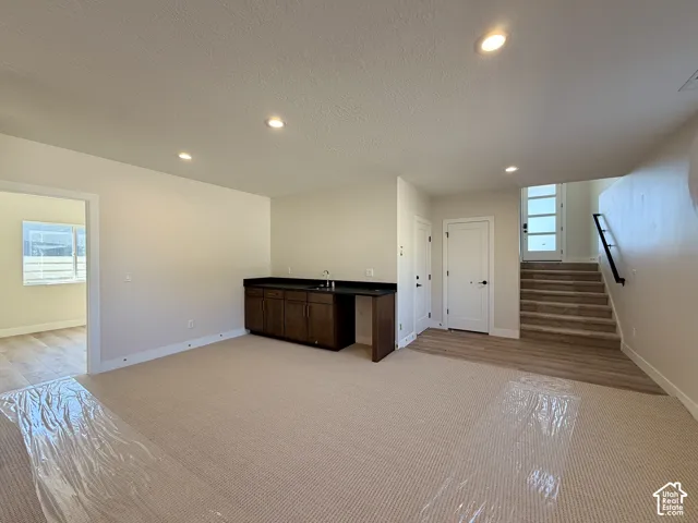 Bonus room featuring wet bar with sink and beverage fridge