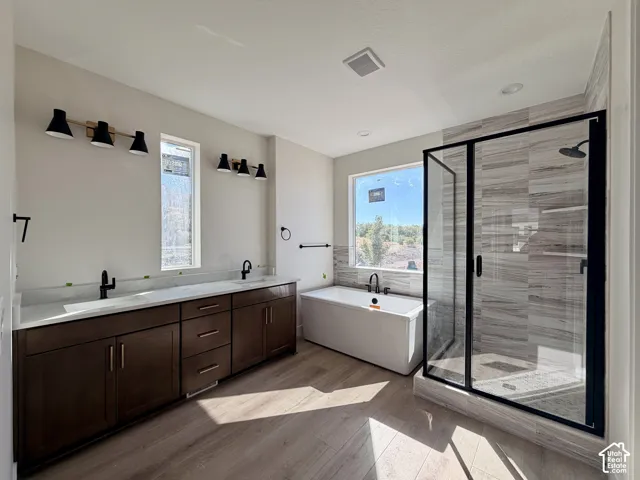 Owner's bath featuring separate soaker tub and walk in shower with marble tile surrounds, double vanity and semi euro shower enclosure