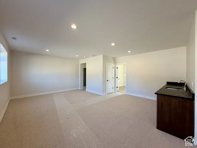 Bonus room featuring wet bar with sink and beverage fridge