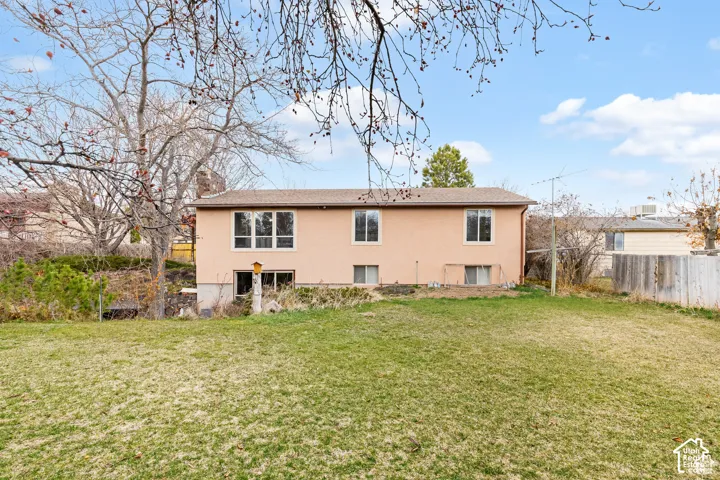 Expansive backyard with a sloped lawn and mature trees