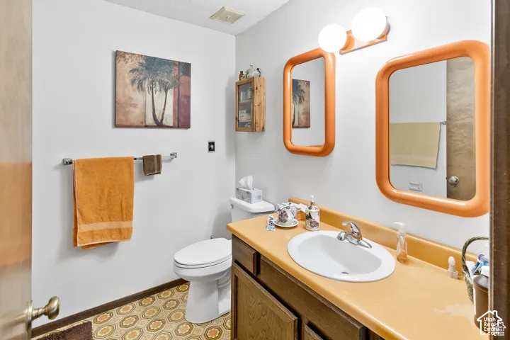 Bathroom featuring a built-in vanity with an integrated sink, wall-mounted lighting, and patterned flooring