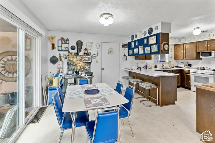 Kitchen featuring wood-finish cabinetry, white countertops, built-in microwave, and a white range