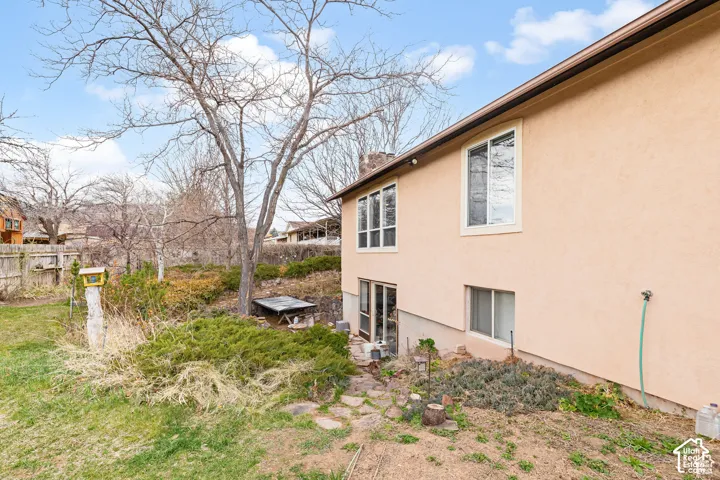 Stucco exterior with multiple windows, featuring a lower-level window and glass-paned door