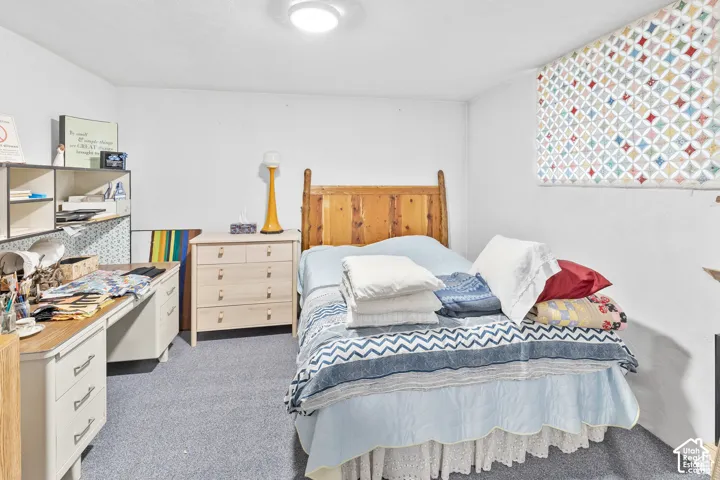 Recessed window, wood headboard, flush-mount ceiling light, built-in shelving, and carpet flooring