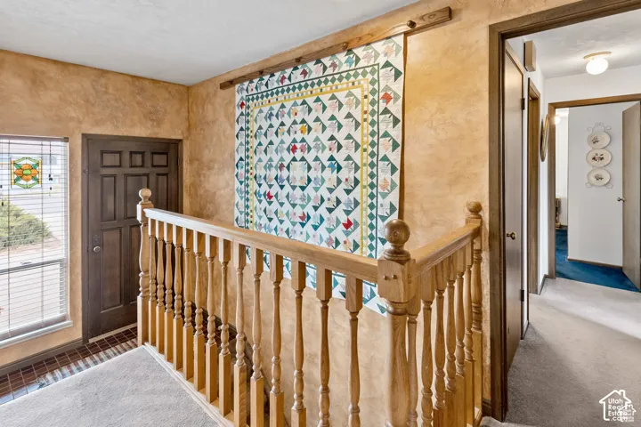 Staircase featuring wooden balusters and handrail
