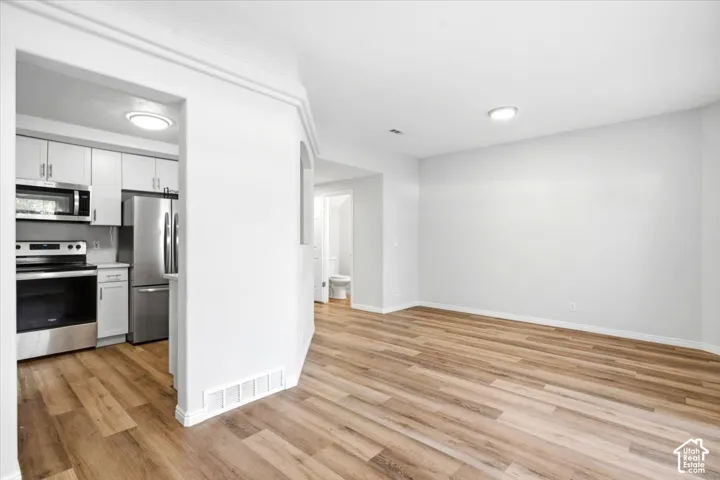 LVP flooring throughout, with a kitchen featuring stainless steel appliances and white cabinetry