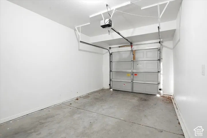 Attached garage with a panel-style garage door and overhead door opener