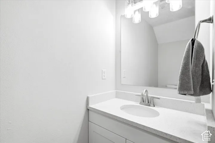 White vanity with an integrated sink, brushed nickel faucet, and a large mirror