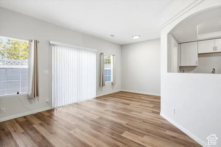 LVP flooring, white walls, recessed lighting, sliding glass door, and an arched pass-through window