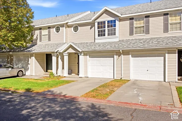 Townhome exterior featuring light-colored siding and a gabled entry