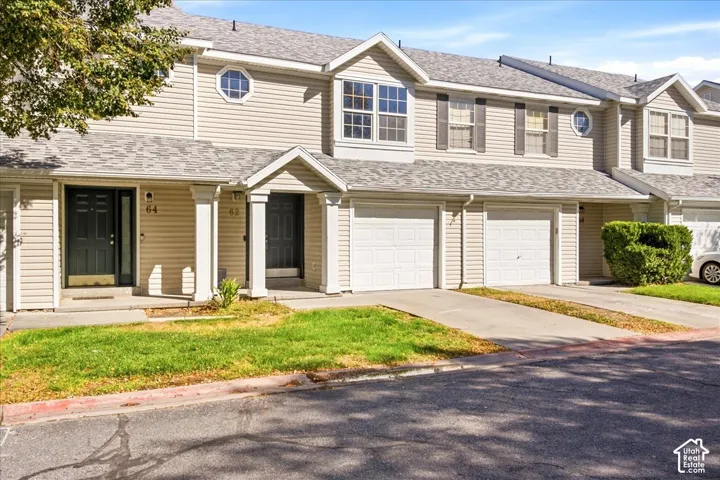 Two-story townhouse exterior with horizontal siding, covered entryways, and attached garage
