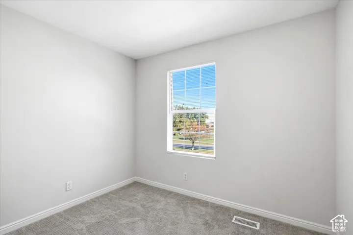 Neutral wall finish, carpeted flooring, and a single window with horizontal blinds